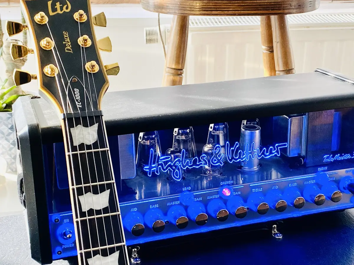 Gitarrenhals vor einem blau leuchtenden Röhrenverstärker